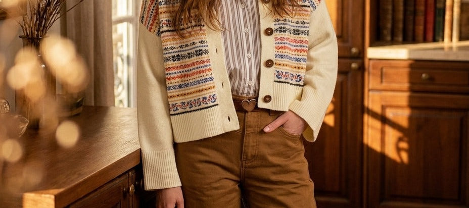 Pantalón Joely beige de Minuit Douze con una chaqueta de punto jacquard color crudo, con la mano en el bolsillo